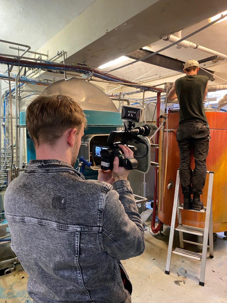 Moritz Kappeler filmt mit einer Kamera in der Hand die Arbeit in einer unterirdischen Brauerei in Berlin.